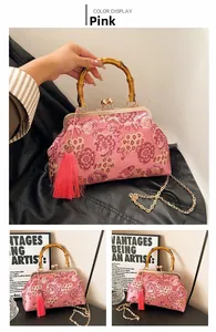 Detail of pink floral embroidery bag with bamboo handle, gold clasp and silk tassel