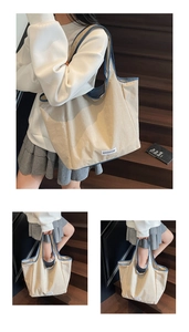 Close-up of beige nylon tote bag with blue contrast trim and brand label detail