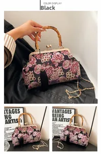 Detail of vintage black embroidered bag with floral patterns and bamboo handle