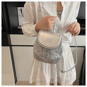 Detail of mini silver backpack with metallic finish, metal chains and cat paw print