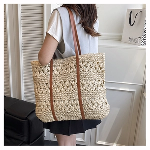 Close-up of hollow floral weave and brown leather straps on straw tote bag