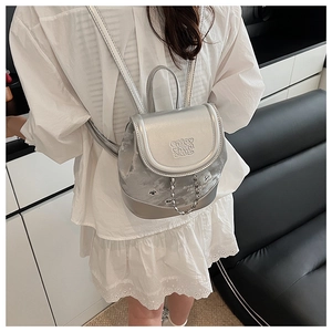 Detail of silver metallic mini backpack with chain and embossed enjoy chan zab letters