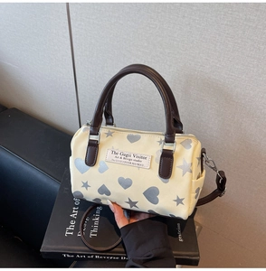 Dettaglio borsa Boston con motivi a cuore argento e tracolla regolabile