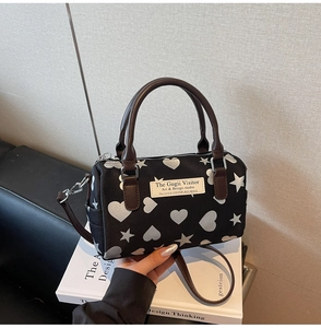 Dettaglio della borsa Boston con stampe di cuori e stelle su tessuto nylon nero