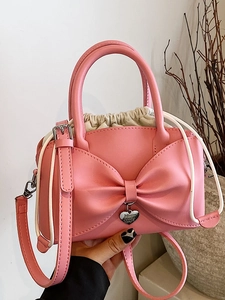Borsa a mano rosa con fiocco, ciondolo a cuore e chiusura con coulisse