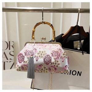 Close-up of vintage embroidery bag with bamboo handle and elegant silk flower patterns