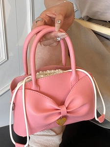 Borsa a mano rosa minimalista con fiocco oversize e ciondolo a cuore dorato elegante