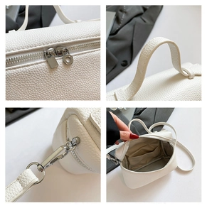 Detail view of white PU leather bag showing dual zippers and reinforced handle