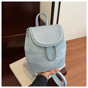 Detail of light blue backpack with PU leather flap and glitter denim fabric and chain