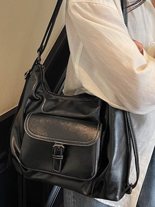 Large black minimalist tote bag with contrast stitching and decorative belt buckle detail
