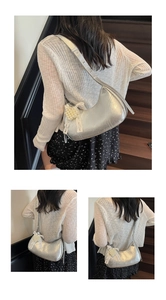 Detailed side view of silver hobo bag with pearl ribbon bow and grainy metallic texture