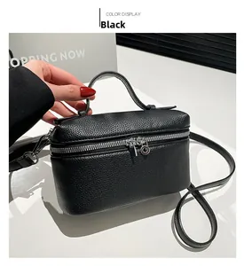 Detail of black lychee grain leather square bag with silver dual zippers and top handle