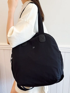 Lightweight black puffy backpack for women with metal DD logo and wide strap for travel