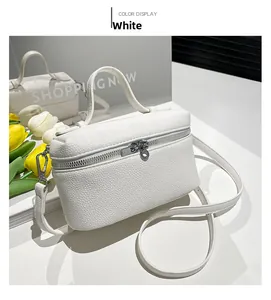 Close-up of a white lychee grain leather box bag with silver ring zipper and tulip decor