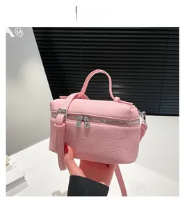 Detail of pink lychee textured mini square handbag with silver zipper and slim strap
