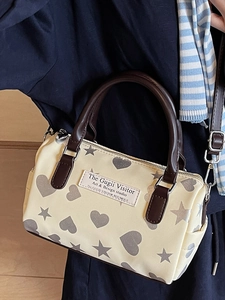 Borsa Boston in tela beige con stampe di cuori e stelle e manici in pelle marrone
