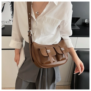 Detail of dark brown leather crossbody bag featuring vintage pockets and silver buckles