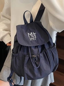Minimalist navy blue nylon backpack with flap closure and white letter embroidery