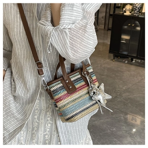 Close-up of rainbow bohemian woven bag showing colorful straw texture and leather straps