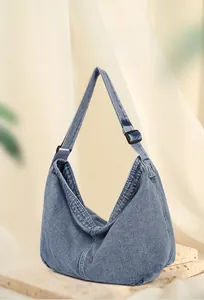 Detail der blauen Denim-Umhängetasche mit Vintage-Textur und breitem Schultergurt