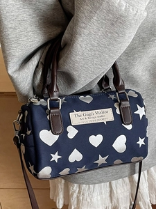 Borsa Boston in tela blu scuro con stampe a stelle e manici in pelle marrone da donna