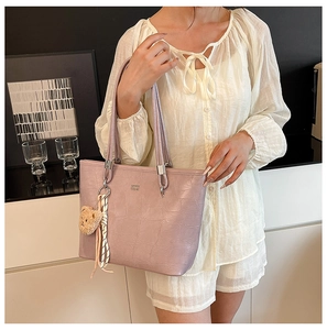 Détail du sac cabas lilas avec texture crocodile et breloque ours en peluche mignonne