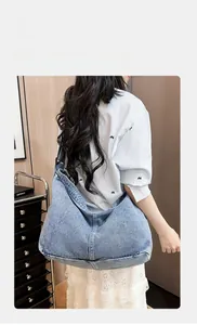 Detail der hellblauen Denim Hobo-Tasche mit breitem Schultergurt an einem Model