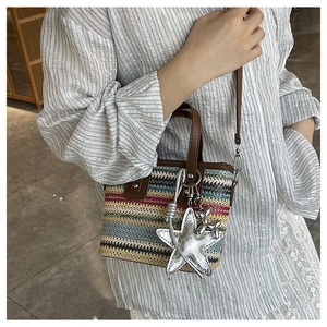 Macro view of multi-colored woven bag texture with silver star charm and brown leather strap