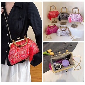 Détail du sac coquillage paisley avec poignée en bambou et pompon en soie élégant