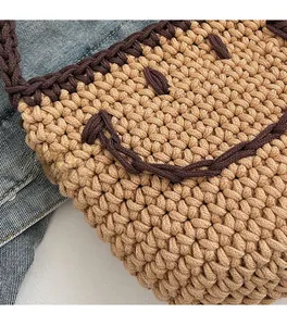 Close-up of the handcrafted knitted texture and smiling face pattern on the bucket bag