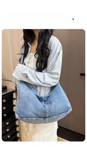 Details der großen Umhängetasche aus gewaschenem Denim mit Stoffstruktur und Halbmondform