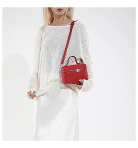 Close-up of red lychee grain leather mini square bag with silver zipper and slim strap