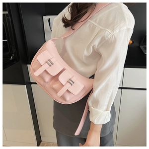 Detail view of pink faux leather crossbody bag featuring dual front pockets and silver buckles