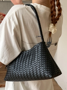 Elegant black woven underarm bag featuring handcrafted leather texture and a classic design
