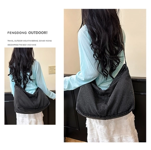 Detail der schwarzen Denim Hobo-Tasche mit breitem Gurt und minimalistischem Design