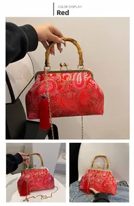 Dettaglio della borsa etnica rossa con ricamo di perle, manico in bambù e nappa