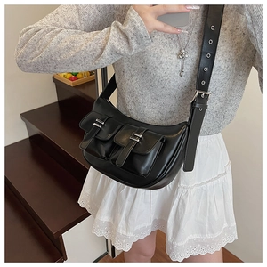 Detail of black leather crossbody bag featuring dual front pockets and silver hardware finish