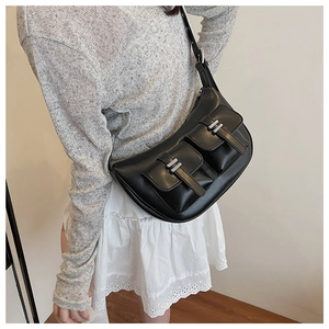Detail view of the black crescent tote bag with utility pockets and silver metal buckles