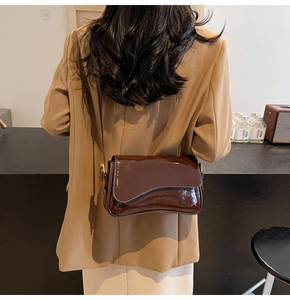 Deep coffee patent leather shoulder bag with saddle curved flap and gold metal buckle