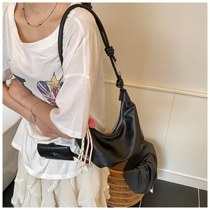 Détail du sac croissant noir avec bandoulière nouée et mini pochette amovible