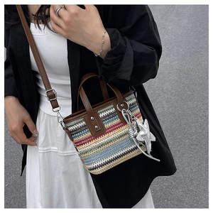 Detail of colorful striped woven handbag with leather handle and silver star charm