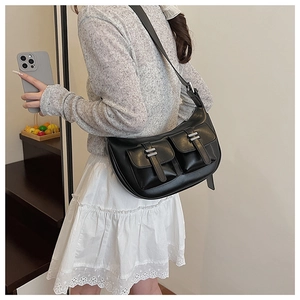 Detail view of black PU leather half-moon bag with double front pockets and adjustable strap