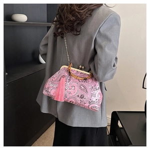 Detail of pink paisley embroidery bag featuring bamboo handle and elegant long tassel