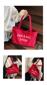 Nahaufnahme der roten Canvas-Tragetasche mit weißer Buchstabenstickerei auf Holztreppen