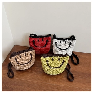 Detailed view of four colorful handmade crochet bucket bags with black smiley face pattern