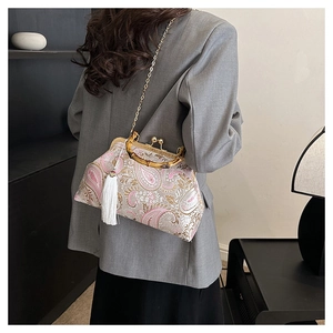 Detail of vintage paisley pattern fabric bag with bamboo handle and white silk tassel detail