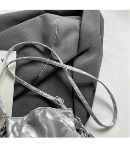 Détail du sac seau plissé argenté avec texture métallique, bandoulière et chaîne