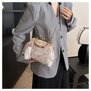 Detail of vintage floral embroidered handbag with bamboo handle and white fringe tassel