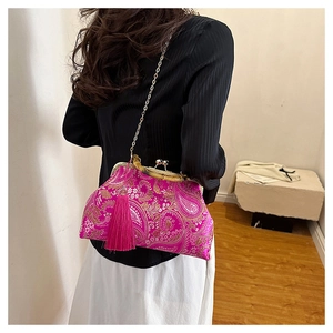 Vue détaillée du sac brodé rose avec poignée en bambou et longue pampille