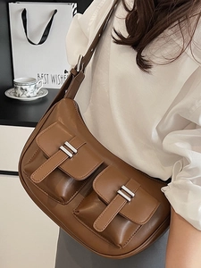 Brown faux leather crescent tote bag with utility pockets and silver hardware